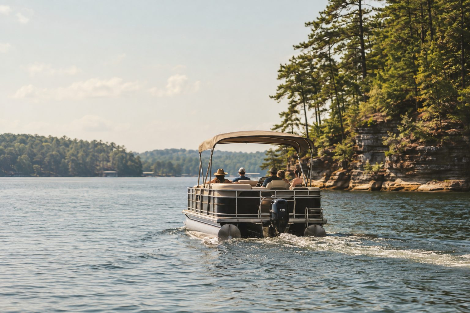 A pontoon boat cruising a wide, pine-lined Alabama lake